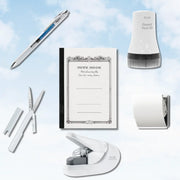 Desk stationery arrangement with a white pen decorative notebook correction tape dispenser scissors tape roll and compact stapler on a soft blue background