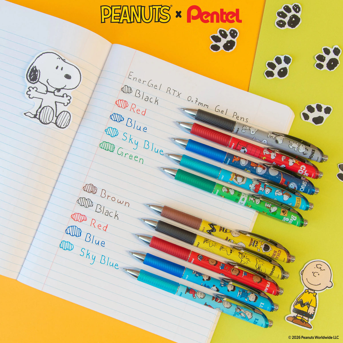 Peanuts and Pentel gel pens in black, red, blue, sky blue, and green arranged on a lined notebook with handwritten color labels and Snoopy artwork