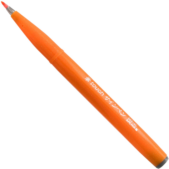 Pentel Arts orange brush tip pen with flexible red bristles and dark end cap for expressive lettering illustration and colorful art supplies