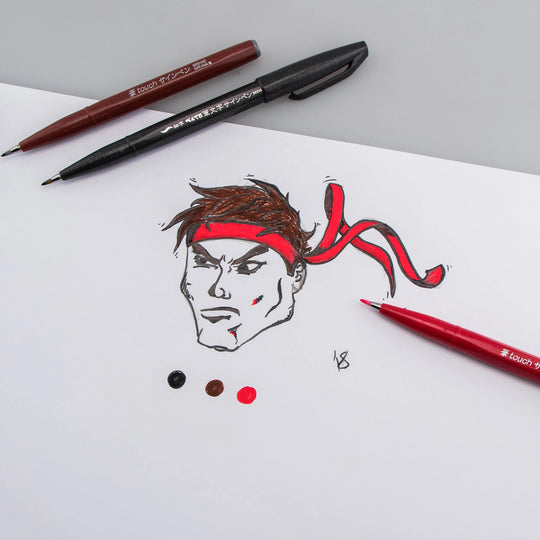 Pentel brush tip pens in black red and brown shown with an expressive ink drawing and colorful swatches on white paper for creative art supplies