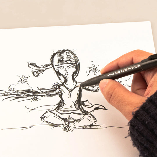 Hand using a black brush tip pen to sketch a detailed seated figure with flowing lines on white paper for expressive artwork and calligraphy practice