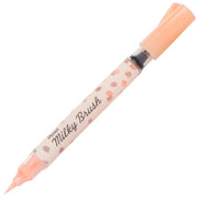 Pentel Arts Milky Brush pen featuring a pale orange pastel ink, designed for smooth, vibrant strokes in creative art projects and premium writing.
