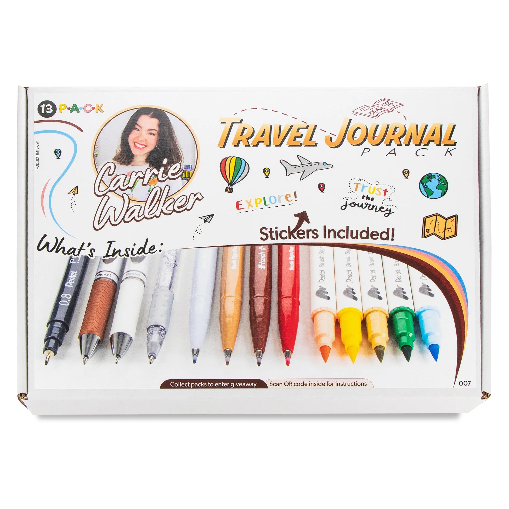 Set of colorful pens, markers, and mechanical pencils displayed on a white box featuring travel-themed illustrations and handwritten text promoting a journaling set with stickers included.